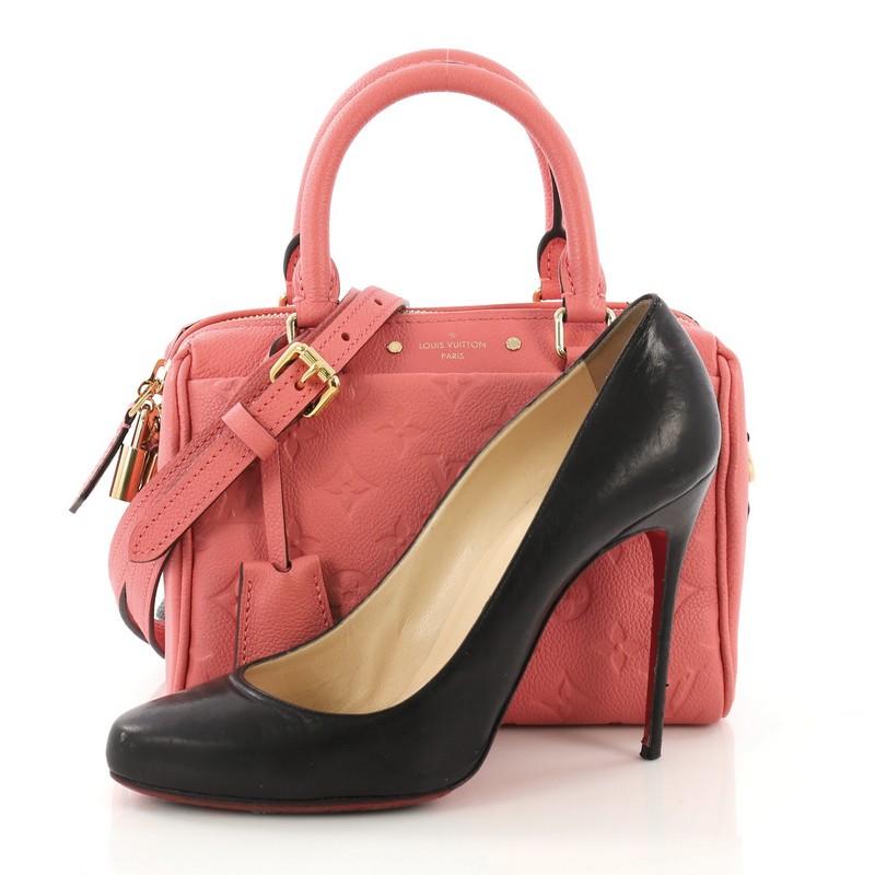 This Louis Vuitton Speedy Bandouliere NM Handbag Monogram Empreinte Leather 20, crafted in pink monogram empreinte leather, features dual rolled leather handles and gold-tone hardware. Its zip closure opens to a pink fabric interior with slip