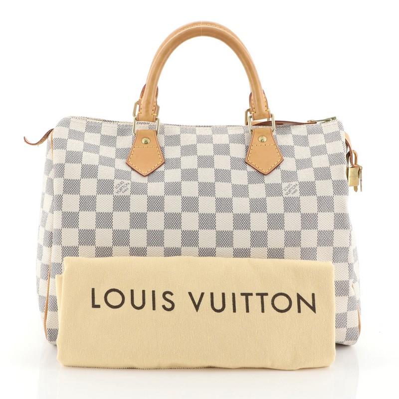 This Louis Vuitton Speedy Handbag Damier 30, crafted in damier azur coated canvas, features dual rolled handles, leather trim, and gold-tone hardware. Its zip closure opens to a neutral fabric interior with slip pocket. Authenticity code reads:
