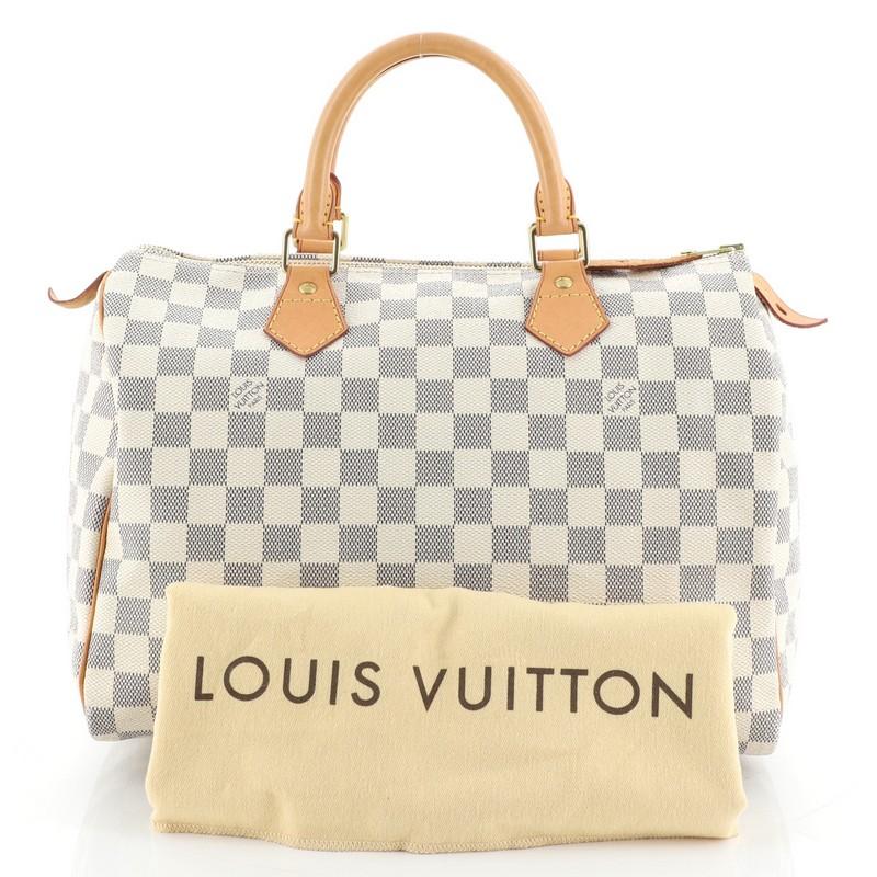 This Louis Vuitton Speedy Handbag Damier 30, crafted in damier azur coated canvas, features dual rolled handles, leather trim, and gold-tone hardware. Its zip closure opens to a neutral fabric interior with zip pocket. Authenticity code reads: