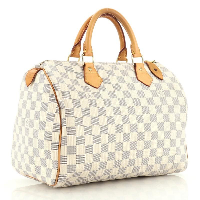 This Louis Vuitton Speedy Handbag Damier 30, crafted in damier azur coated canvas, features dual rolled handles, leather trim, and gold-tone hardware. Its zip closure opens to a neutral fabric interior with zip pocket. Authenticity code reads: