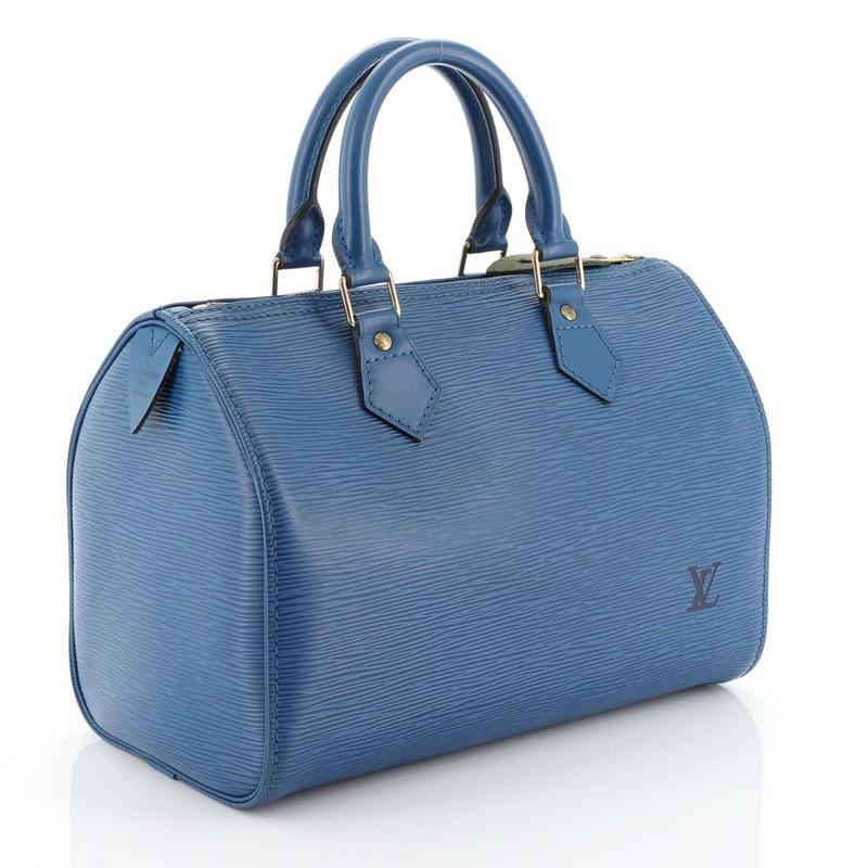 This Louis Vuitton Speedy Handbag Epi Leather 25, crafted from blue epi leather, features dual rolled leather handles, exterior side pocket, and gold-tone hardware. Its zip closure opens to a neutral raw leather interior. Authenticity code reads: