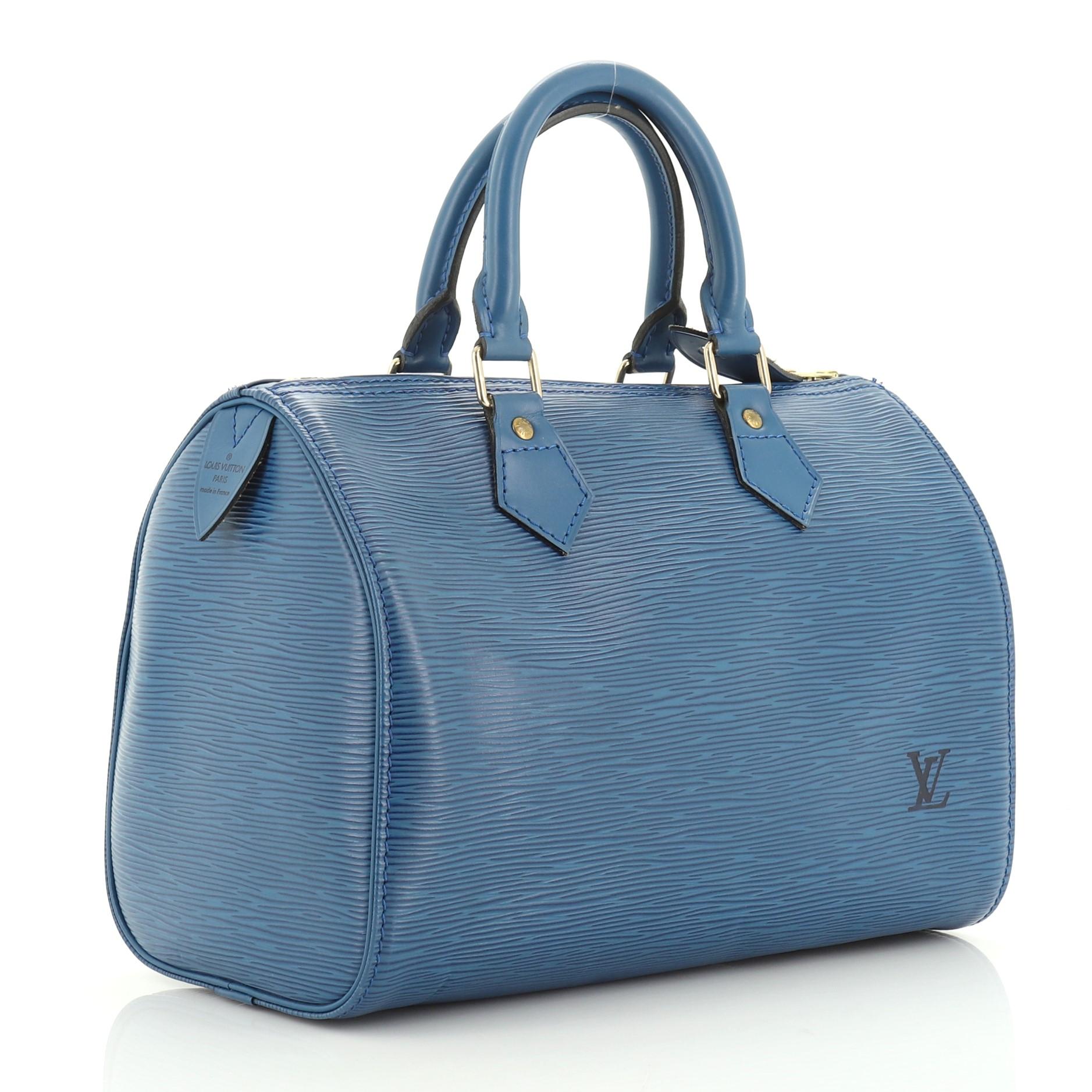 This Louis Vuitton Speedy Handbag Epi Leather 25, crafted from blue epi leather, features dual rolled leather handles, exterior side pocket, and gold-tone hardware. Its zip closure opens to a blue raw leather interior. Authenticity code reads:
