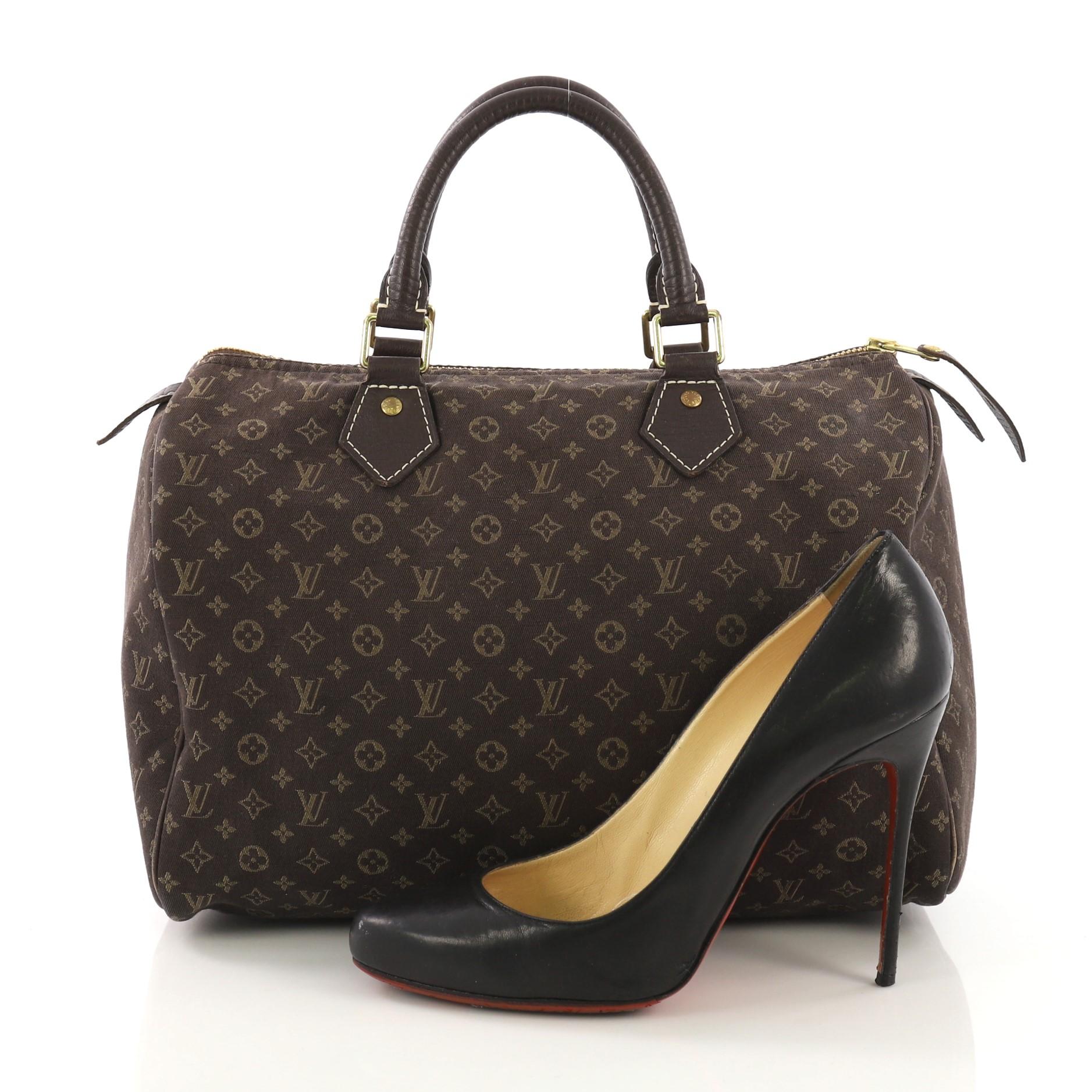 This Louis Vuitton Speedy Handbag Mini Lin 30, crafted from brown monogram mini lin canvas, features dark brown cowhide leather handles and trim, white contrast stitching and gold-tone hardware. Its zip closure opens to a brown fabric interior with