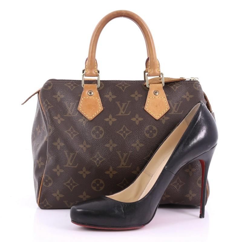 This Louis Vuitton Speedy Handbag Monogram Canvas 25, crafted in brown monogram coated canvas, features dual rolled leather handles, vachetta leather trims, and gold-tone hardware. Its zip closure opens to a brown fabric interior with slip pocket.