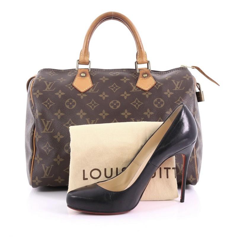 This Louis Vuitton Speedy Handbag Monogram Canvas 30, crafted in brown monogram coated canvas, features dual rolled leather handles, leather trims, and gold-tone hardware. Its top zip closure opens to a brown fabric interior with slip pocket.