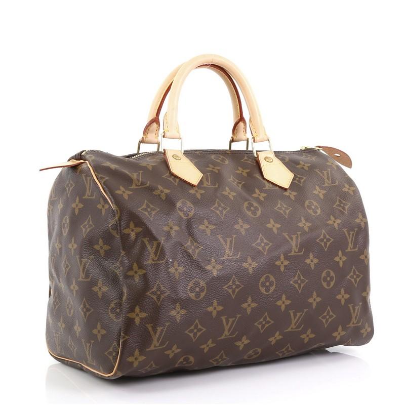 This Louis Vuitton Speedy Handbag Monogram Canvas 30, crafted in brown monogram coated canvas, features dual rolled leather handles, vachetta leather trim, and gold-tone hardware. Its zip closure opens to a brown fabric interior with slip pocket.