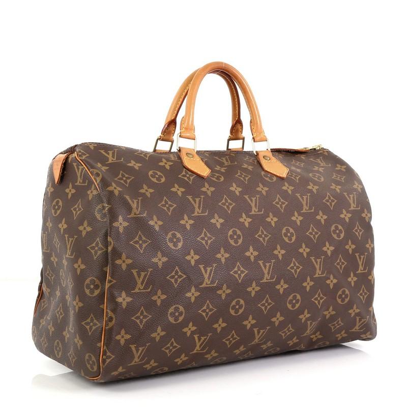 This Louis Vuitton Speedy Handbag Monogram Canvas 40, crafted in brown monogram coated canvas, features dual rolled leather handles, vachetta leather trim, and gold-tone hardware. Its zip closure opens to a brown fabric interior with zip pocket.