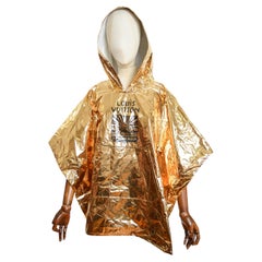 LOUIS VUITTON Invitación al desfile Primavera Verano 2024 - Poncho dorado de recuerdo del festival