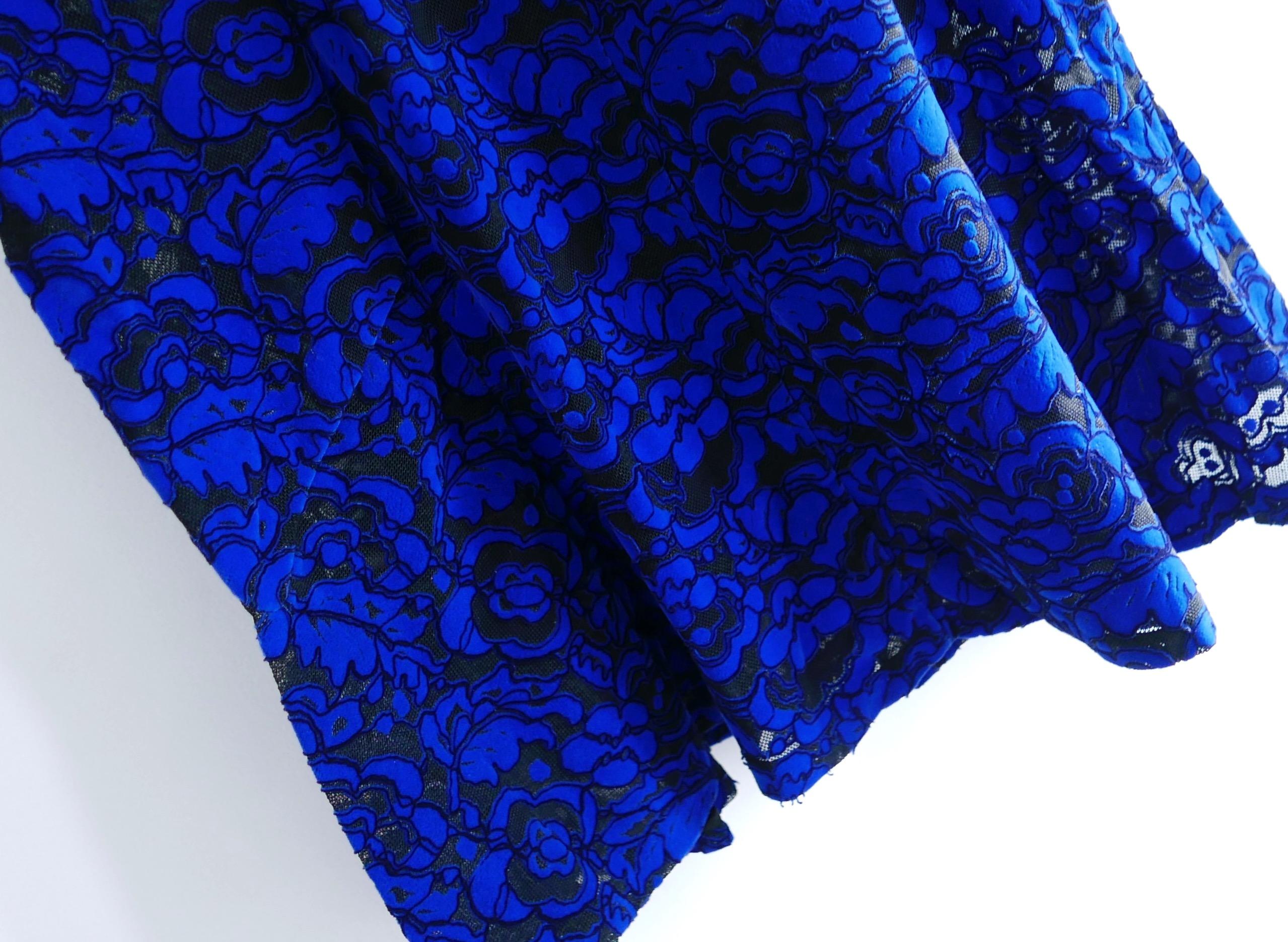 Favoloso abito floccato Louis Vuitton d'archivio della collezione primavera 2017. È stato lavato a secco. Realizzato in rete floccata a trama floreale blu elettrico e nera, presenta un orlo svasato, vita con pinces e maniche corte. Viene fornito con