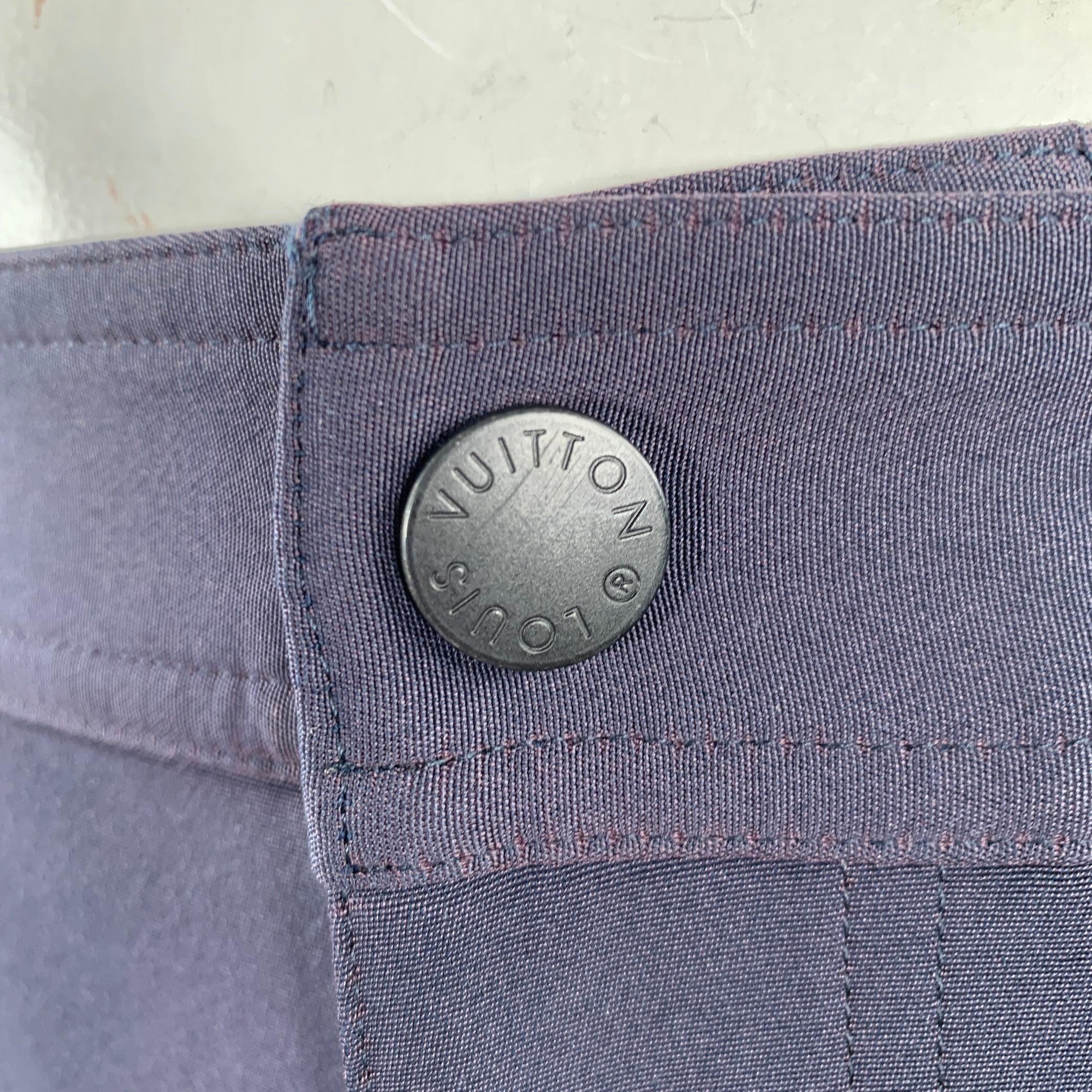 LOUIS VUITTON by Virgil Abloh SS19 pantalon décontracté
en polyester bleu marine, avec un style utilitaire, des poches zippées et une fermeture à glissière.
Fabriqué en Italie. Très bon état. Signes d'usure sur les boutons-pression latéraux.