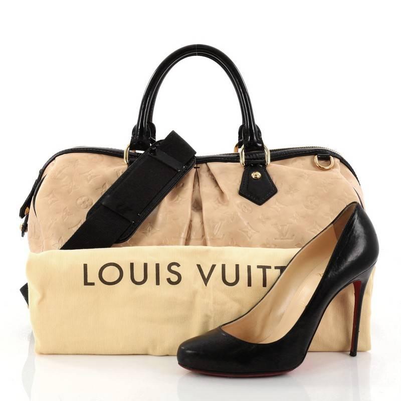 This authentic Louis Vuitton Stephen Handbag Monogram Embossed Leather is a unique coveted piece created by iconic artist Stephen Sprouse. Crafted from tan monogram embossed leather, this duffle bag features dual-rolled black patent leather handles,