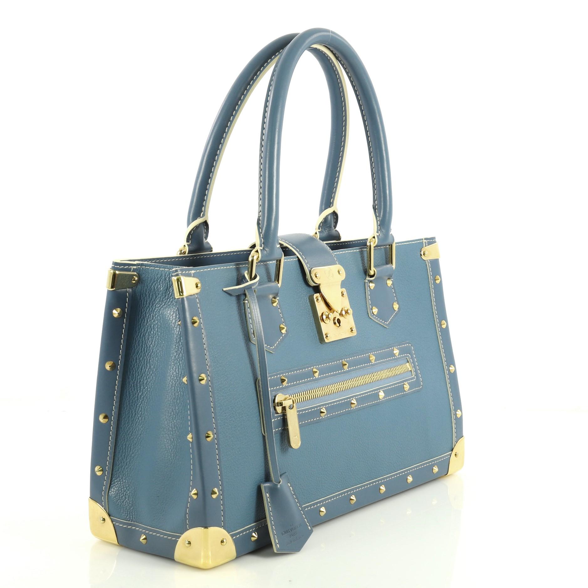 This Louis Vuitton Suhali Le Fabuleux Handbag Leather, crafted in blue leather, features dual rolled handles, exterior front zip pocket, corner plates and decorative studs, and gold-tone hardware. Its S-lock closure opens to a gray fabric interior