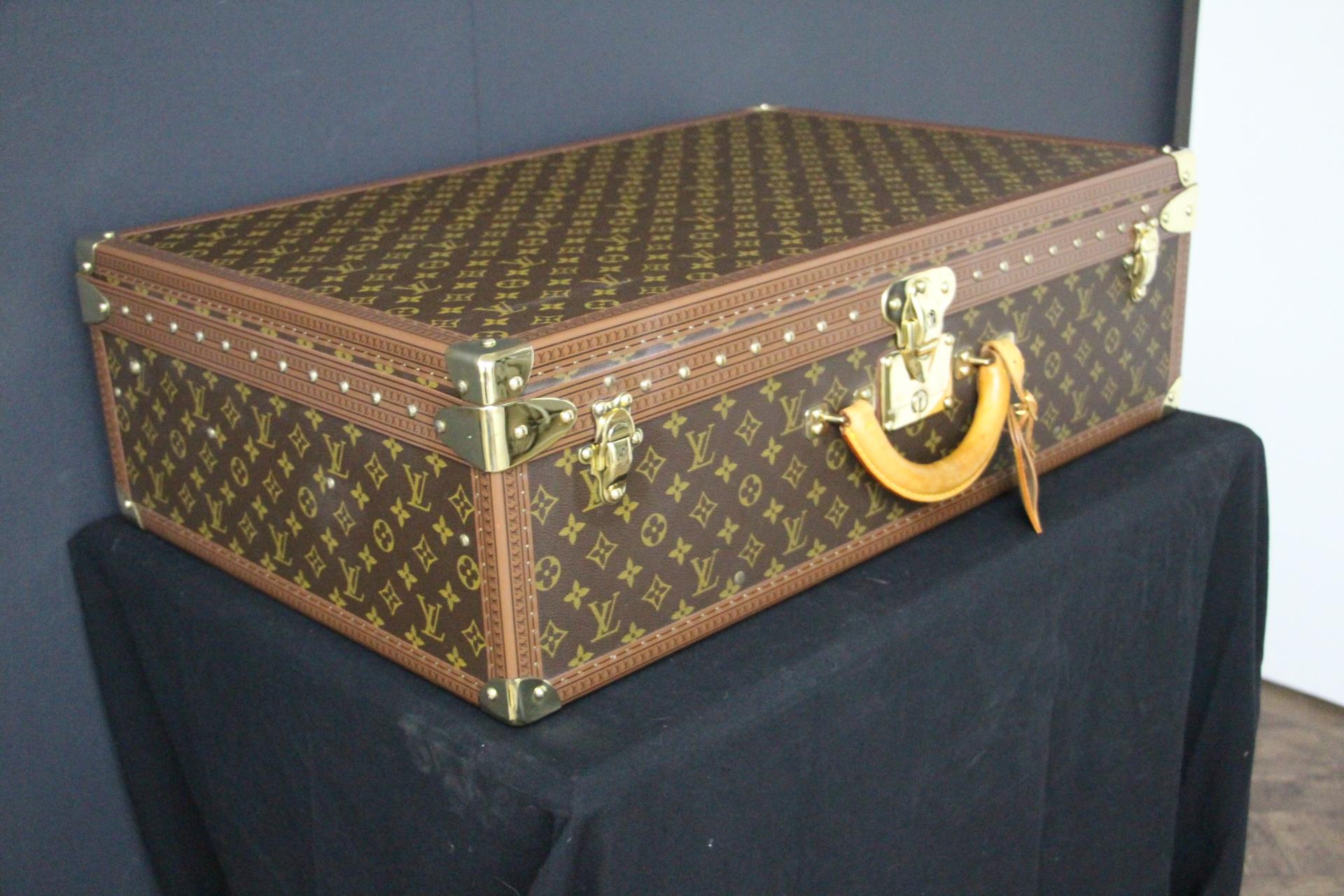 This is a magnificent Louis Vuitton Alzer monogramm suitcase. It features 
all Louis Vuitton stamped solid brass fittings: locks, clasps and studs.Its trim is stamped LV everywhere too.
It has got a large and comfortable all leather handle .
As to