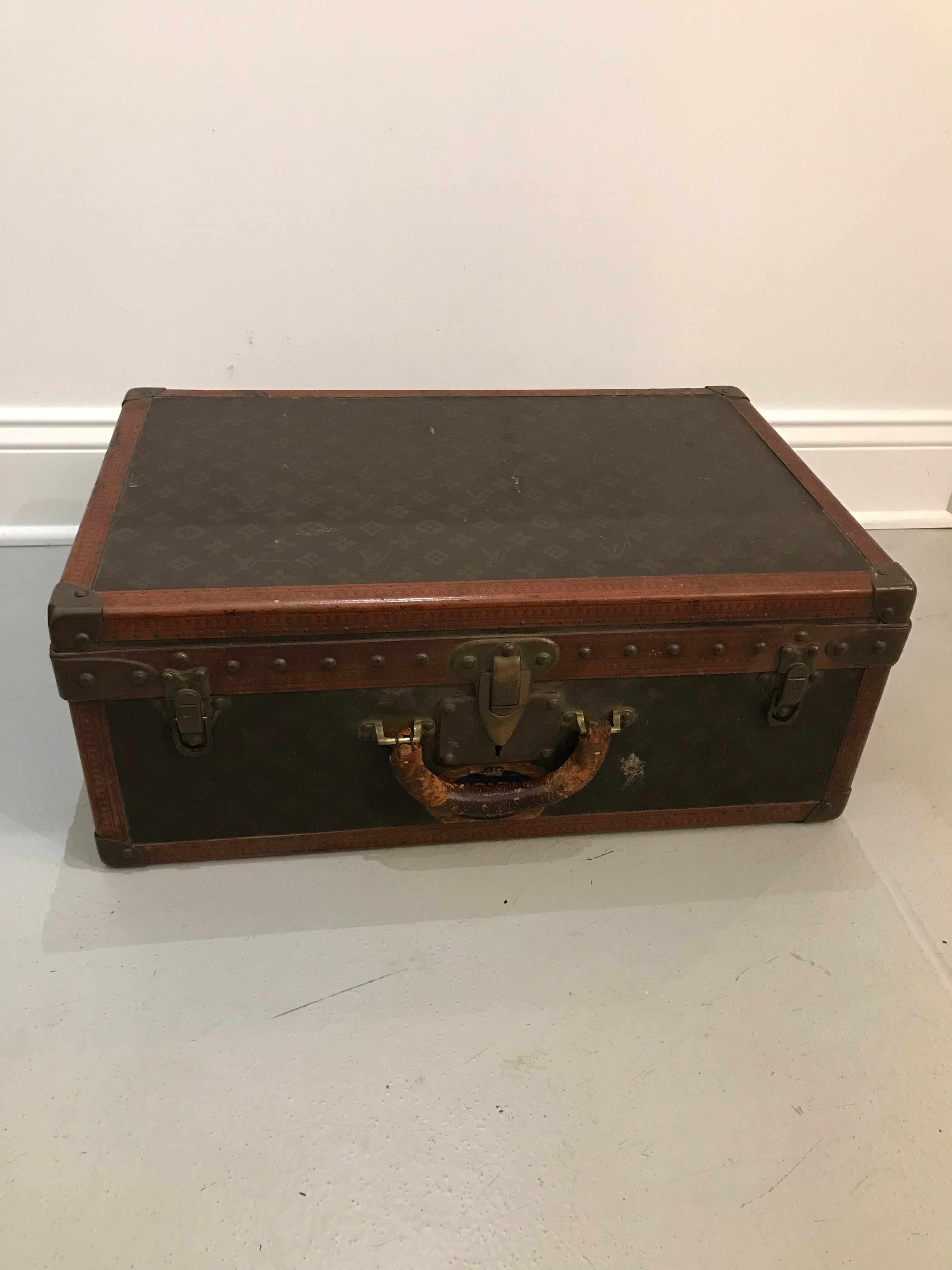 French, 20th century. A Louis Vuitton suitcase with a monogram canvas exterior, leather and brass-bound (all rivets and hardware are marked), opens to fitted interior with removable tray, labelled on interior lid with stamped serial number 792647