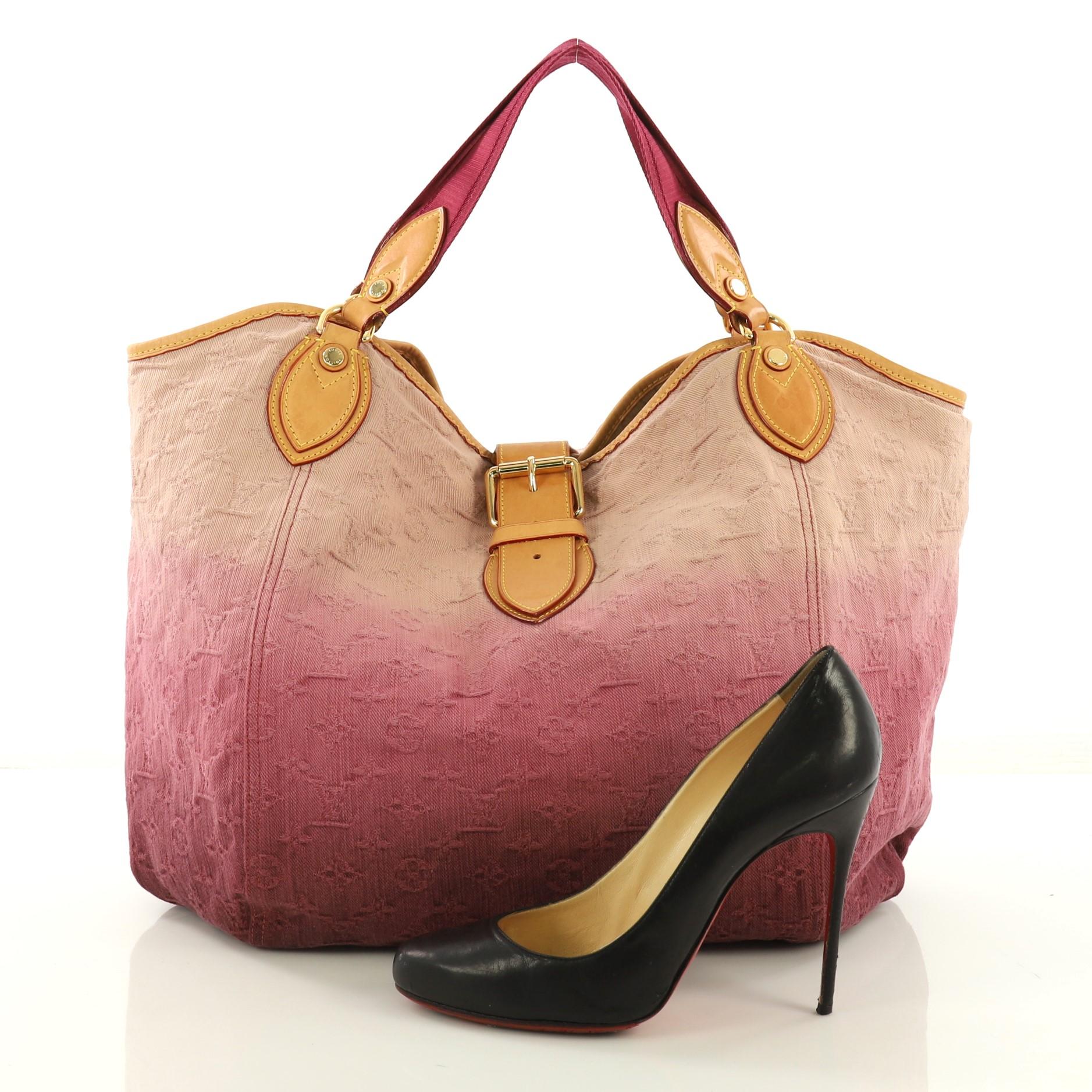 This Louis Vuitton Sunbeam Handbag Denim, crafted in pink ombre denim, features dual top handles, vachetta leather trim, and gold-tone hardware. Its belt and buckle closure opens to a beige microfiber interior with side zip and slip pockets.