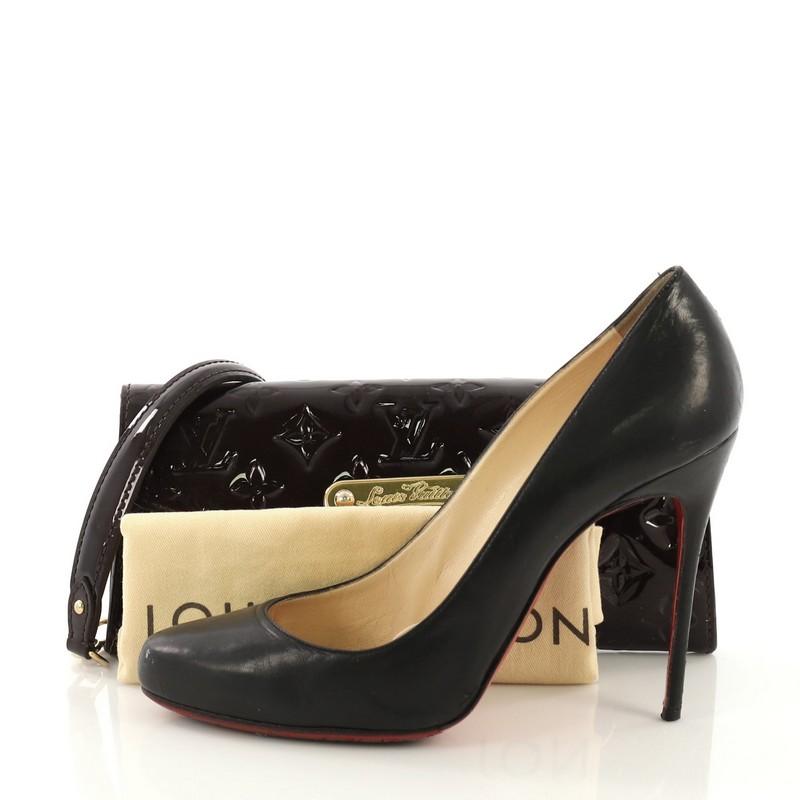 This Louis Vuitton Sunset Boulevard Handbag Monogram Vernis, crafted in amarante monogram vernis leather, features a chain link with leather strap, engraved logo plate and gold-tone hardware. Its magnetic snap closure opens to a burgundy fabric and