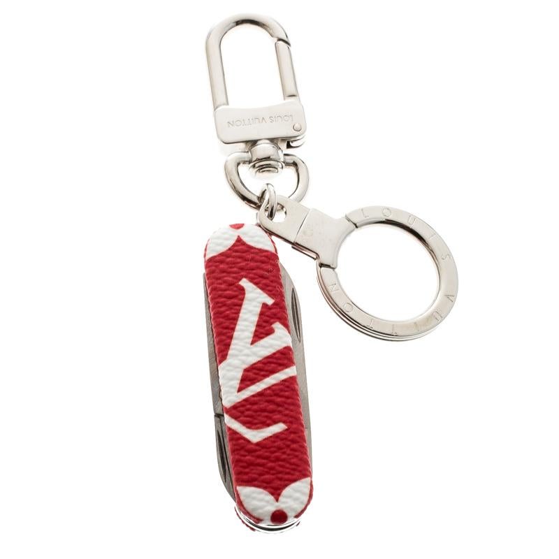 This charming key ring from Louis Vuitton can also be used as a pocket knife. This one is rendered in red monogram coated canvas and features a silver-tone ring and snap hook along with concealed knives and a pair of scissors. An accessory, both