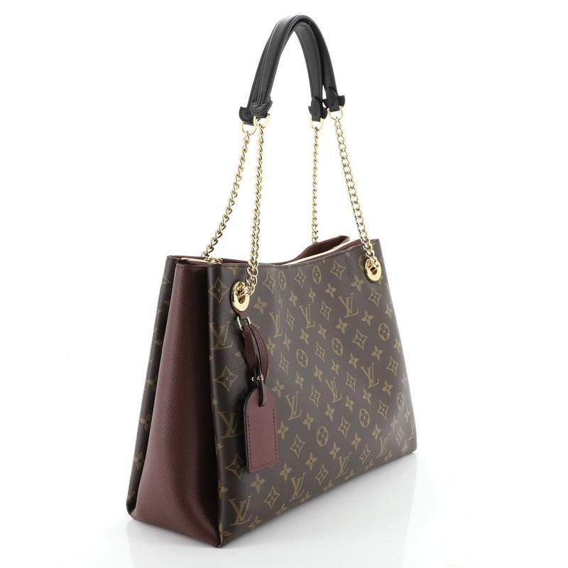 This Louis Vuitton Surene Handbag Monogram Canvas with Leather MM, crafted from brown monogram coated canvas with red leather, features dual chain link straps with leather pads and gold-tone hardware. It opens to a red microfiber interior with two