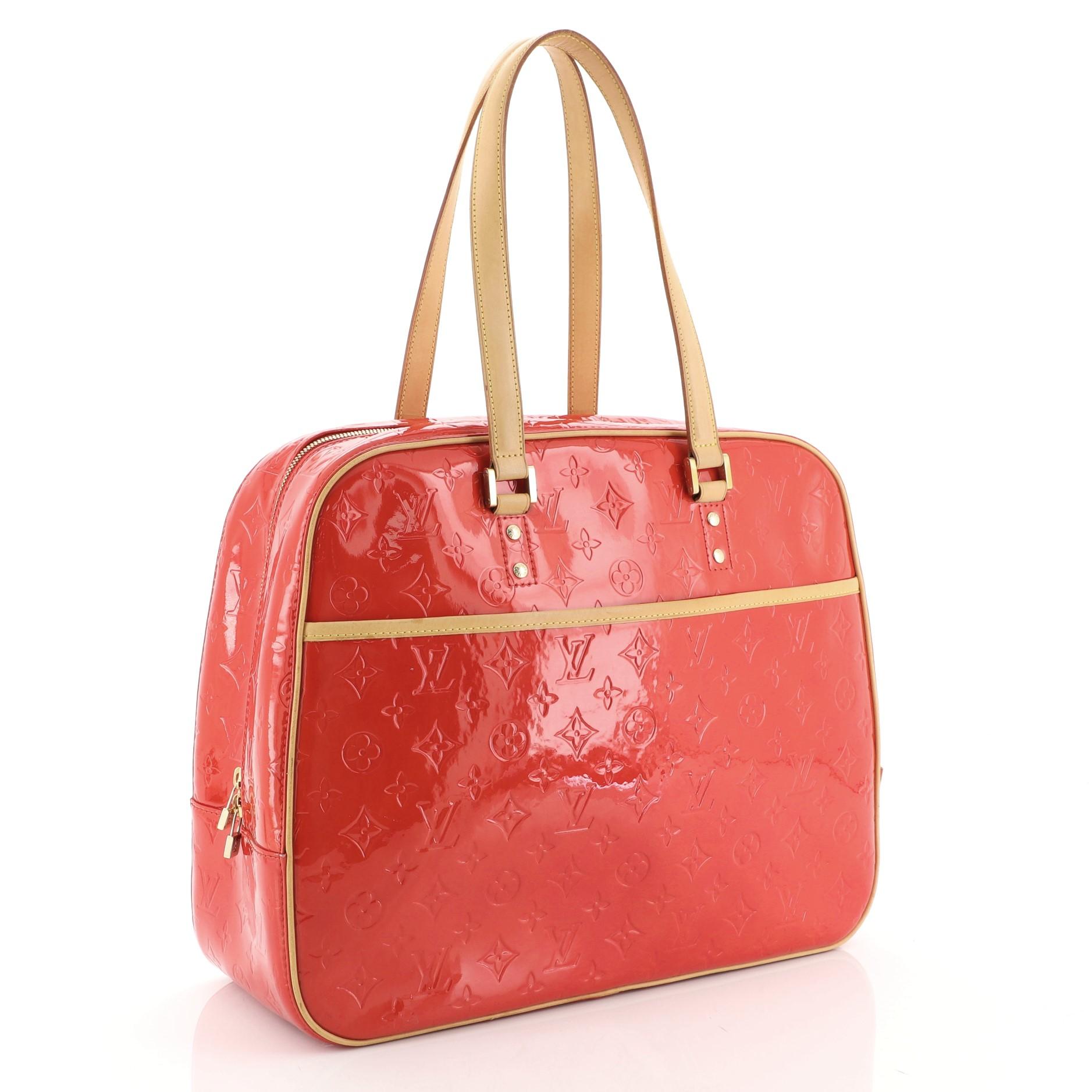 This Louis Vuitton Sutton Handbag Monogram Vernis, crafted from red monogram vernis leather, features dual vachetta leather shoulder straps, vachetta leather trim, exterior front pocket and gold-tone hardware. Its zip closure opens to a red leather