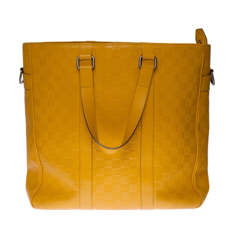 The indispensable Louis Vuitton Tadao shoulder bag in checkered yellow leather, black silver metal hardware, double handle in yellow leather, removable shoulder strap handle in yellow leather allowing a hand or shoulder or shoulder strap.

Zip