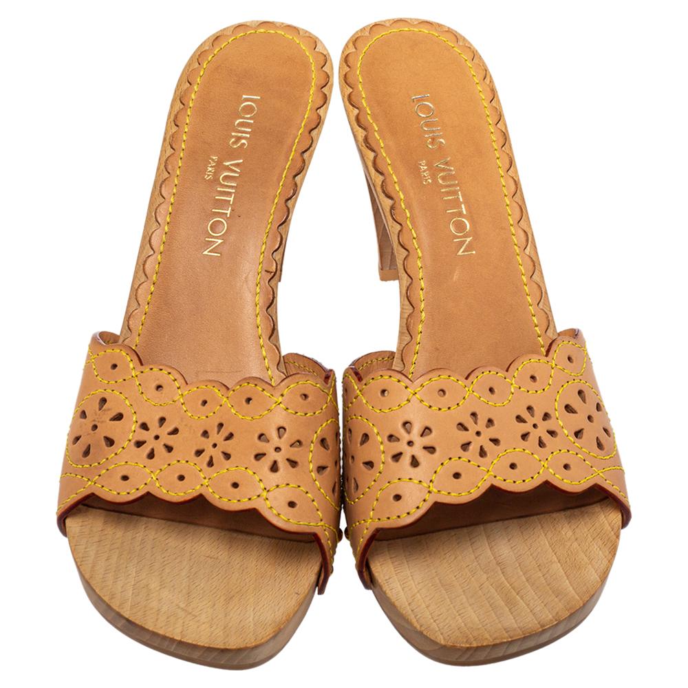 These stunning sandals by Louis Vuitton are a perfect example of the brand's fine craftsmanship. Crafted from leather, they come in a lovely tan hue. They feature a cutout vamp and clog heels. They are the epitome of elegance.

