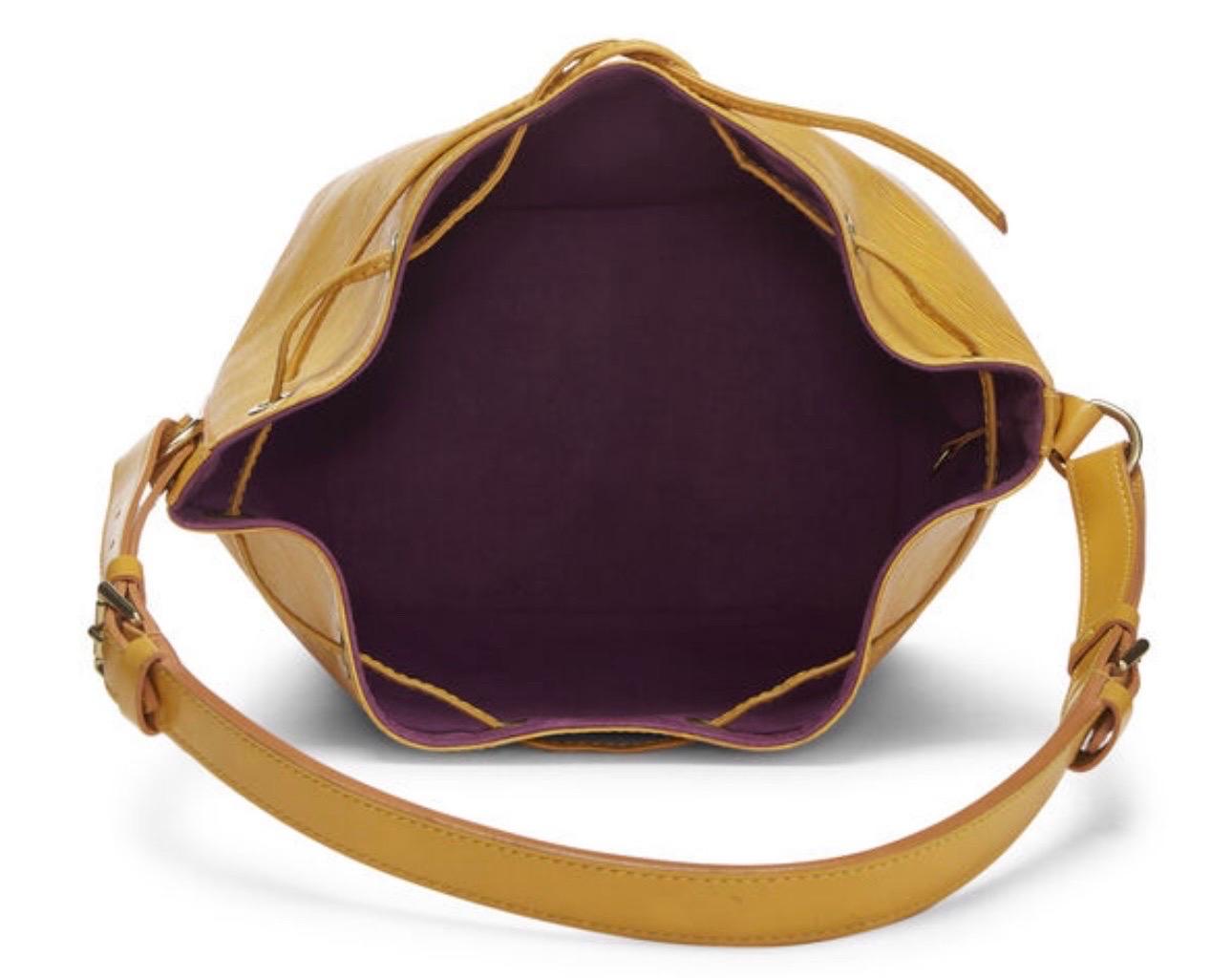 Sac seau classique Noé en petite taille, réalisé en cuir Epi strié jaune Tassil avec des accents en cuir lisse, avec des ferrures en laiton doré et une fermeture à cordon.

À propos du Noé : L'histoire d'un sac peut-elle être plus passionnante que