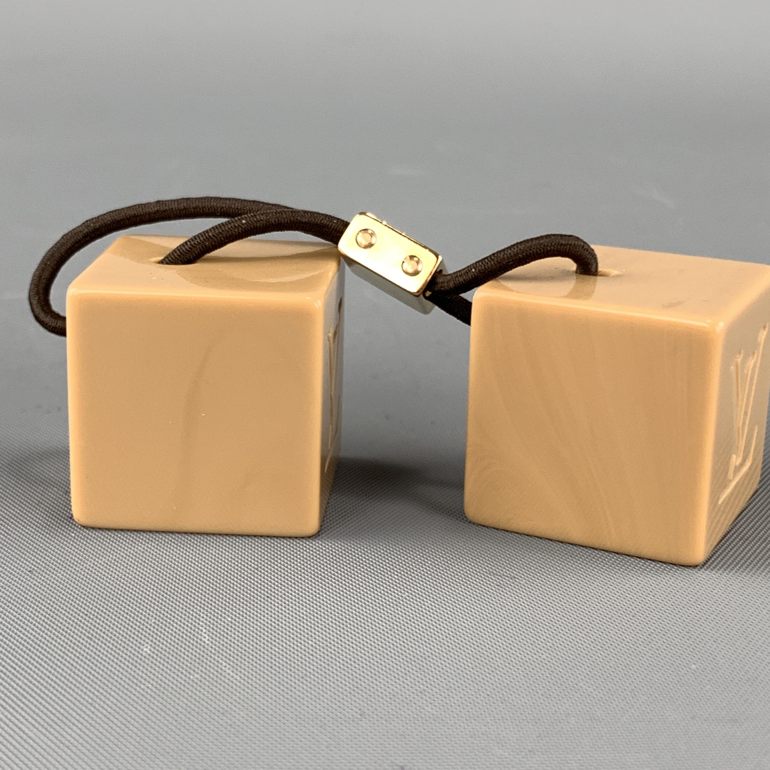 Vintage LOUIS VUITTON hair band comes features a stretch hair tie wit gold tone metal accent and taupe cubes with LV monogram logo. With ust bag.

Excellent Pre-Owned Condition.

Cube: 2.5 cm.