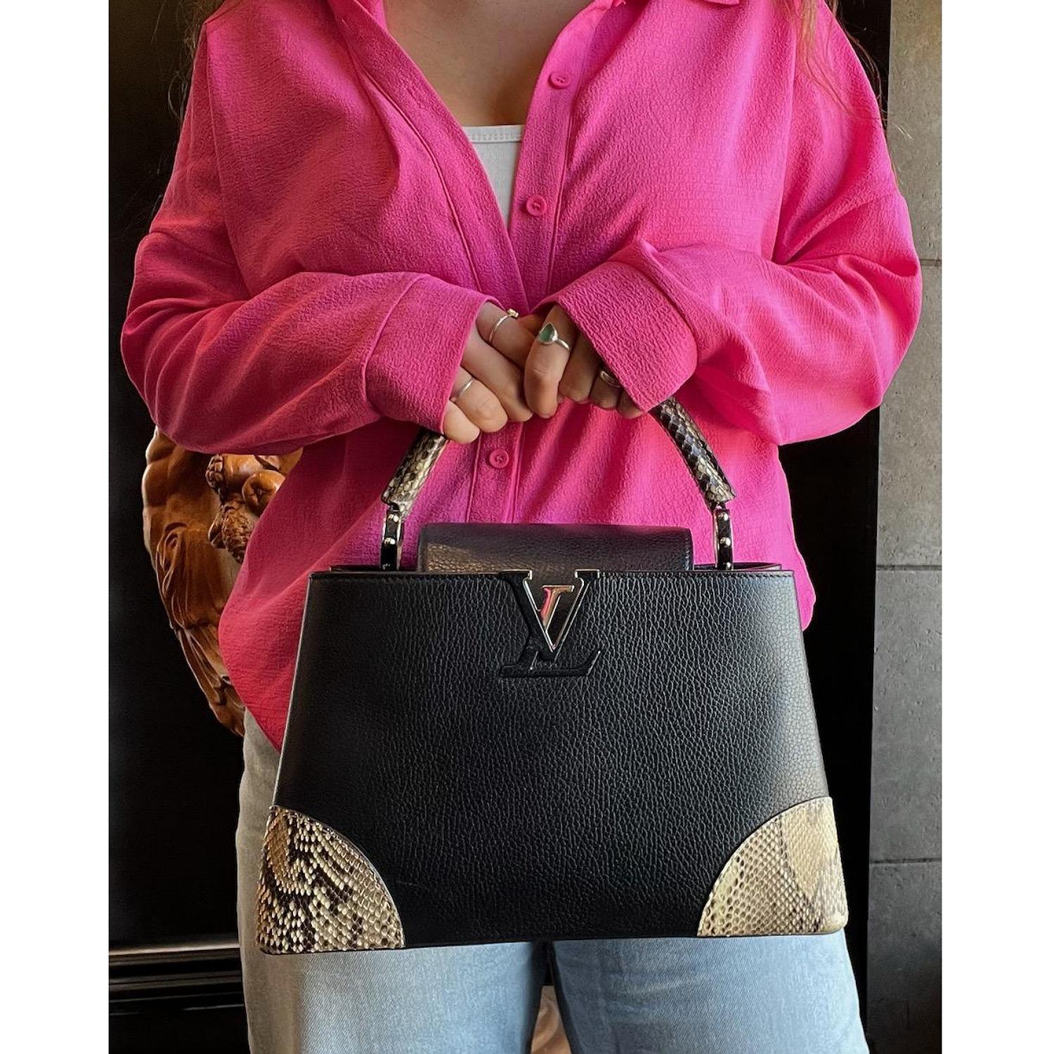 This stylish handbag is crafted of beautiful full grain taurillon calfskin leather in black. This stylish hand bag features a rolled watersnake top handle and trim, polished silver studded ring handle links. A small crossover flap with a silver