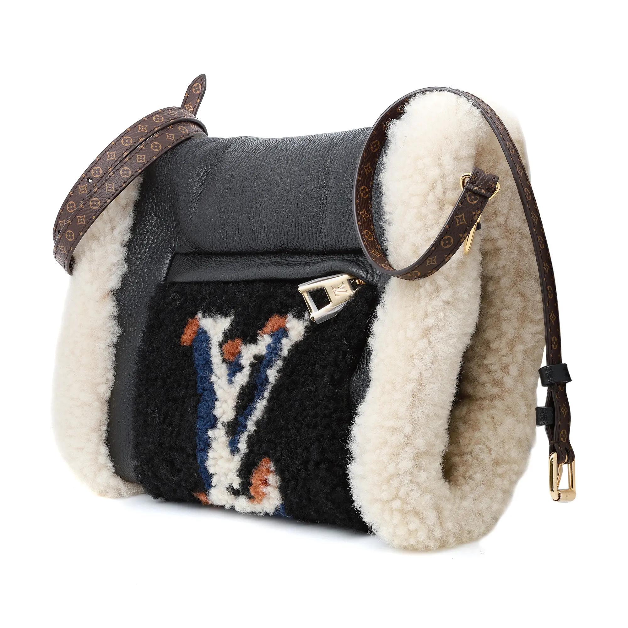 Louis Vuitton Calfskin Monogram Teddy Muffle Black Bag. Ce porte-monnaie iconique à la pointe de la mode se transforme en sac à bandoulière. En cuir grainé noir, il est orné d'un monogramme LV surdimensionné sur un molleton de shearling. La poche