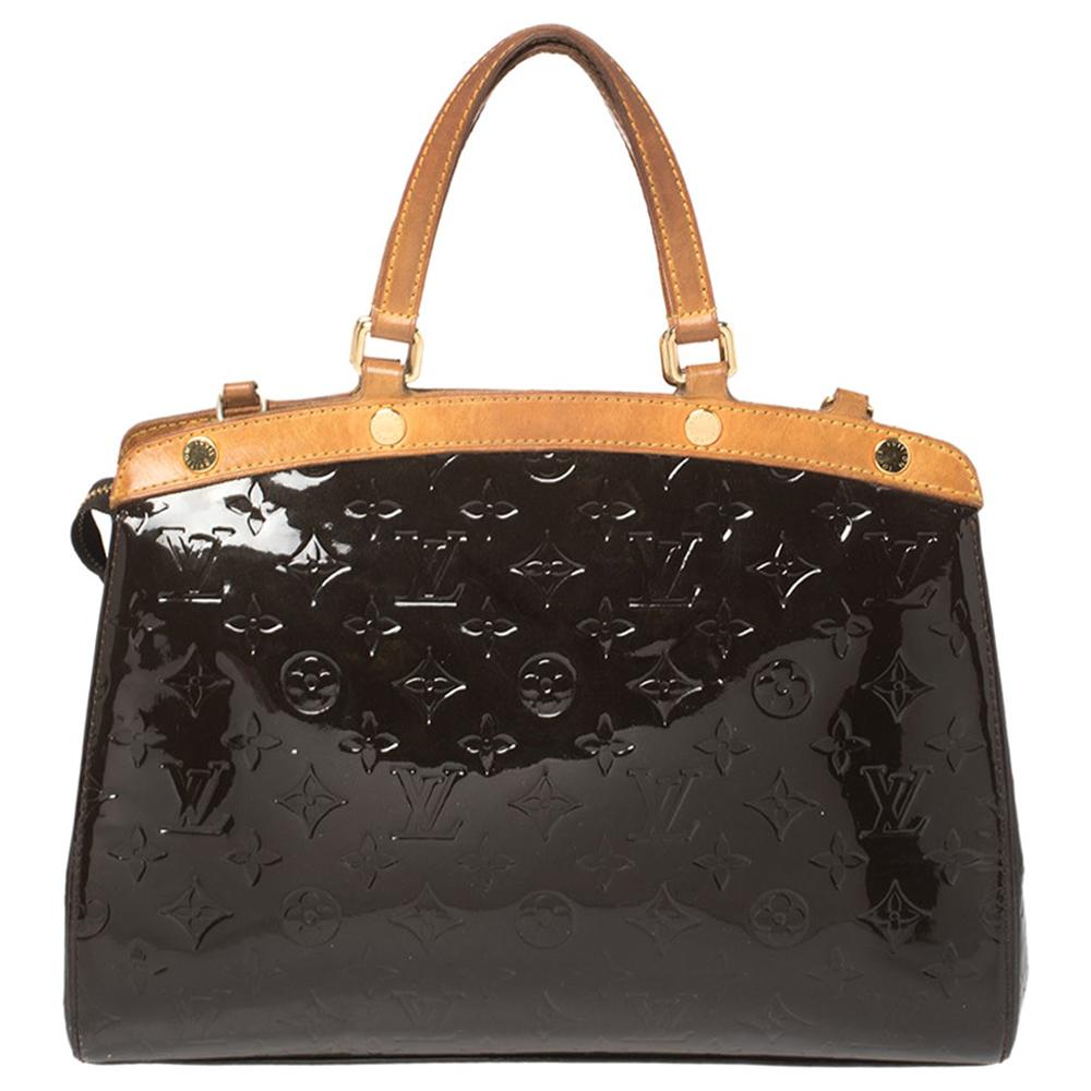 The feminine shape of Louis Vuitton's Brea is inspired by the doctor's bag. Crafted from Monogram Vernis leather in burgundy, the bag has a perfect finish. The fabric interior is spacious and it is secured by a zipper. The bag features double