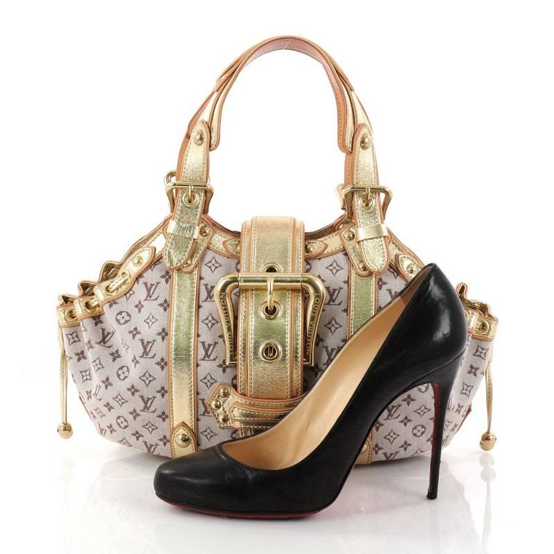 This authentic Louis Vuitton Theda Handbag Mini Lin GM showcases a balance of feminine style with classic design. Constructed with Louis Vuitton's signature taupe monogram mini lin with metallic gold leather trimmings, this limited edition bag