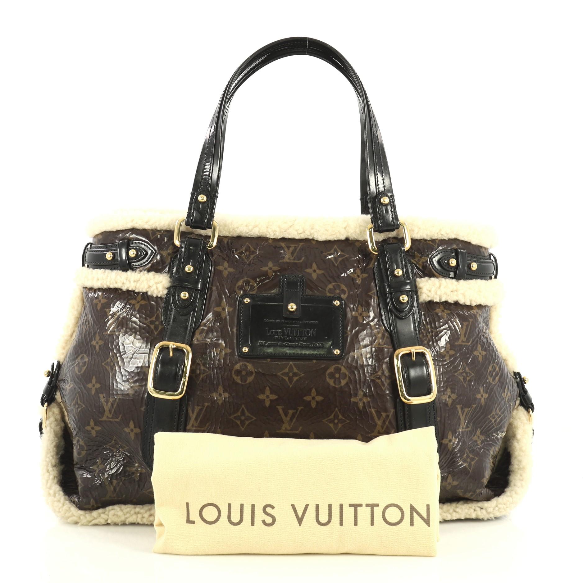 This Louis Vuitton Thunder Handbag Limited Edition Monogram and Shearling, crafted in brown monogram leather and shearling, features dual flat leather handles, Louis Vuitton Inventeur plaque, and gold-tone hardware. Its snap button closure opens to