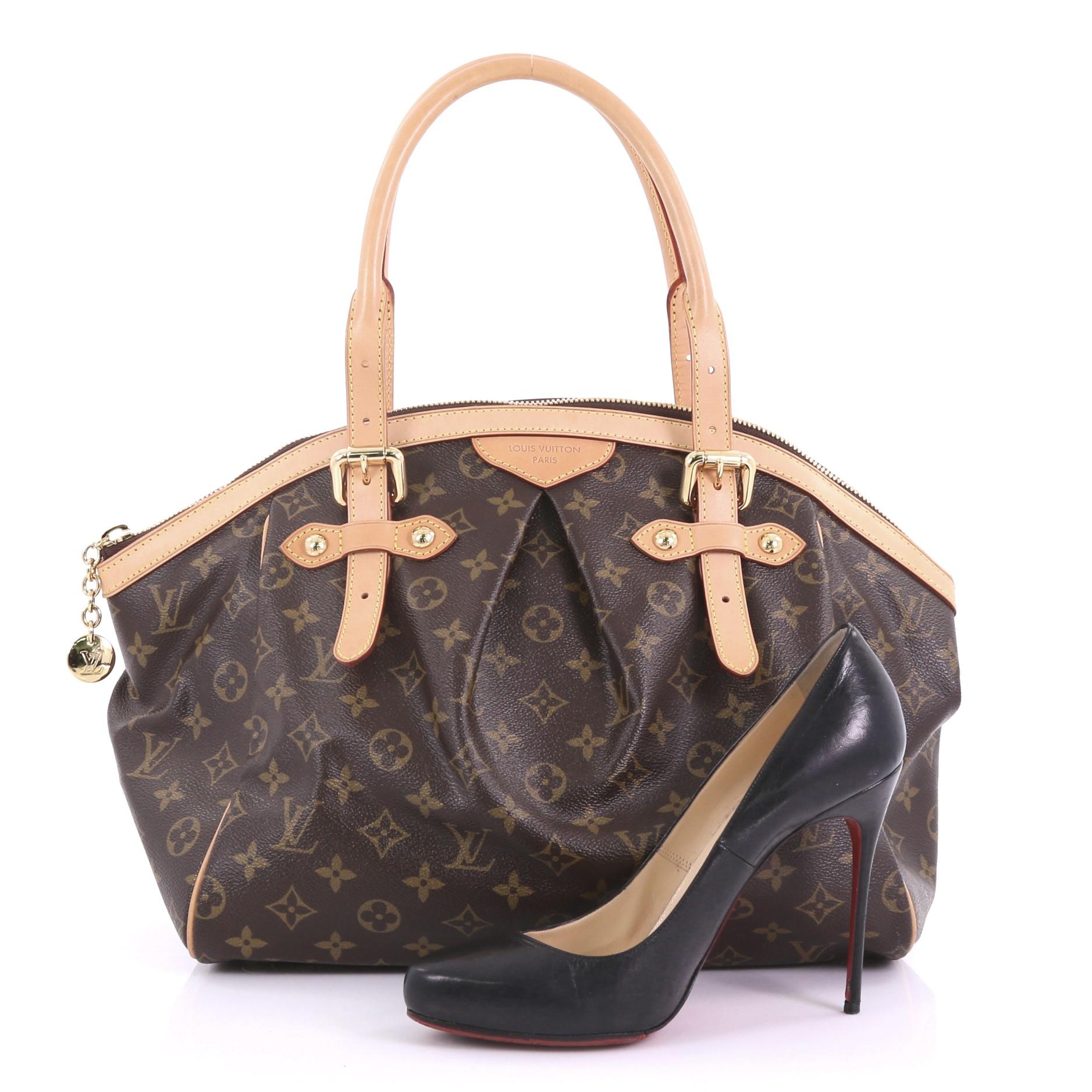 This Louis Vuitton Tivoli Handbag Monogram Canvas GM, crafted from brown monogram coated canvas, features dual rolled handles, subtle pleats in the middle, and gold-tone hardware. Its top zip closure opens to a brown fabric interior with slip