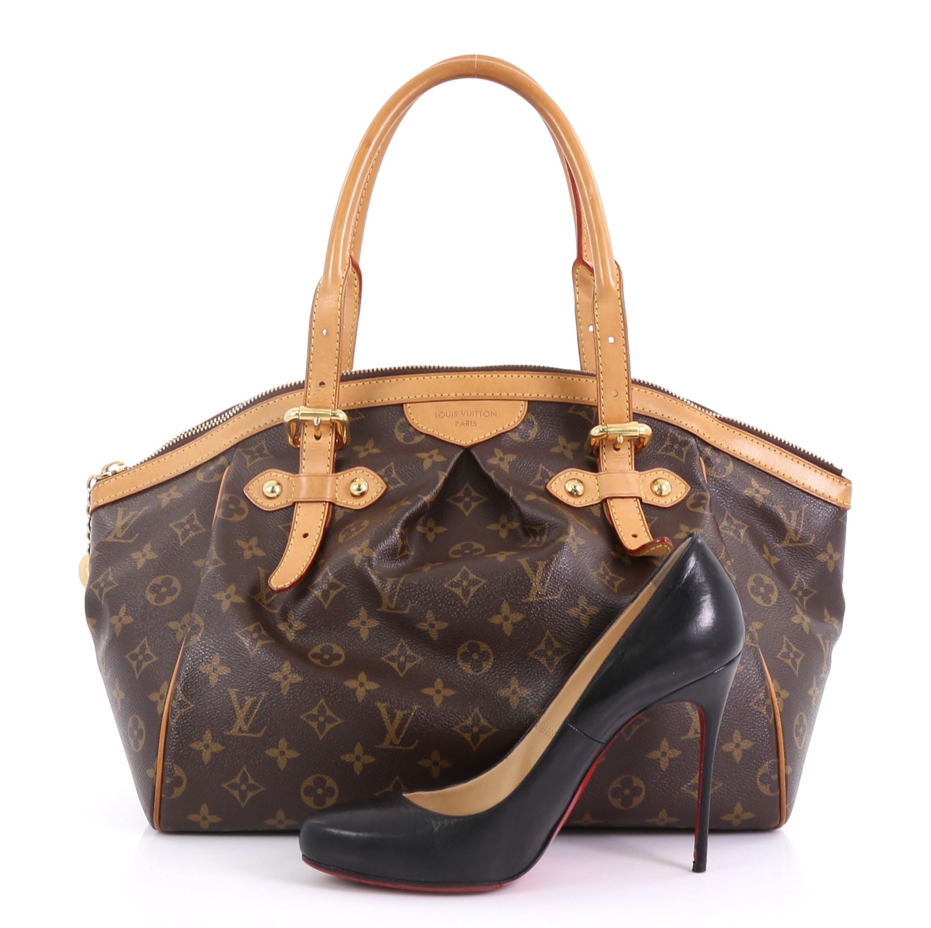 This Louis Vuitton Tivoli Handbag Monogram Canvas GM, crafted from brown monogram coated canvas, features dual rolled handles, subtle pleats in the middle, and gold-tone hardware. Its top zip closure opens to a brown fabric interior with slip