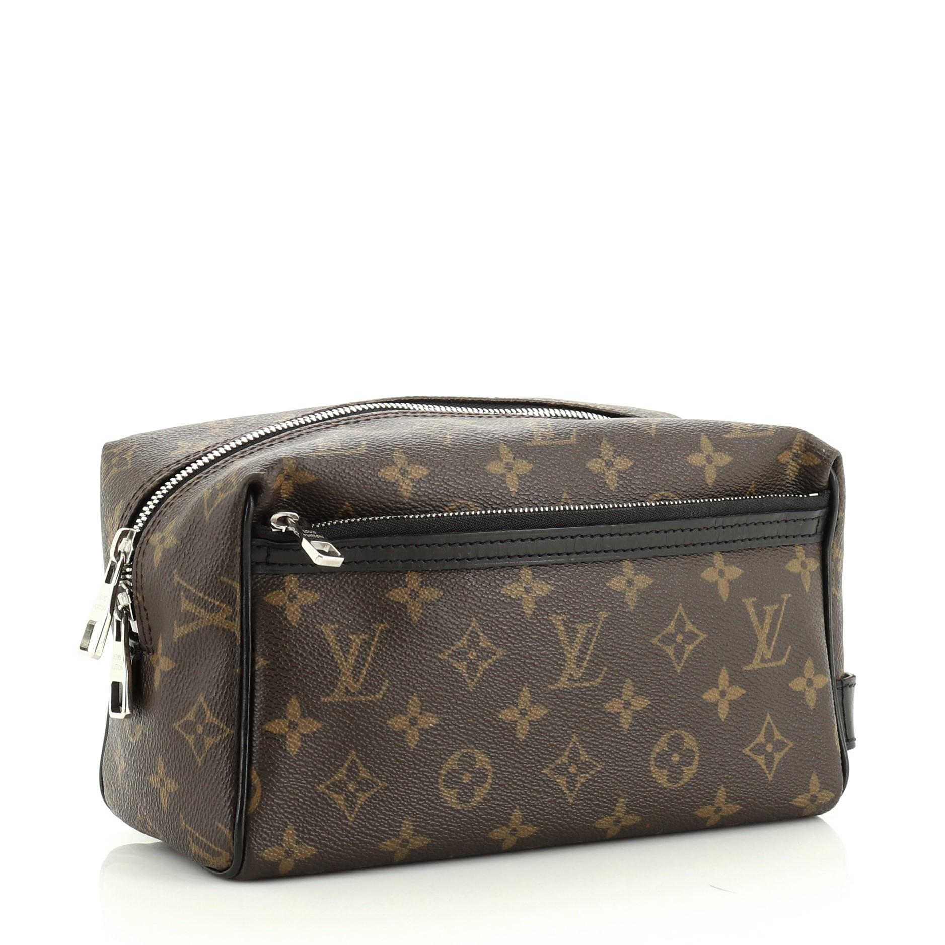 This Louis Vuitton Toiletry Kit Bag Macassar Monogram Canvas, crafted from brown monogram coated canvas, features exterior zip pocket and silver-tone hardware. Its zip closure opens to a purple leather interior. Authenticity code reads: BA1130.