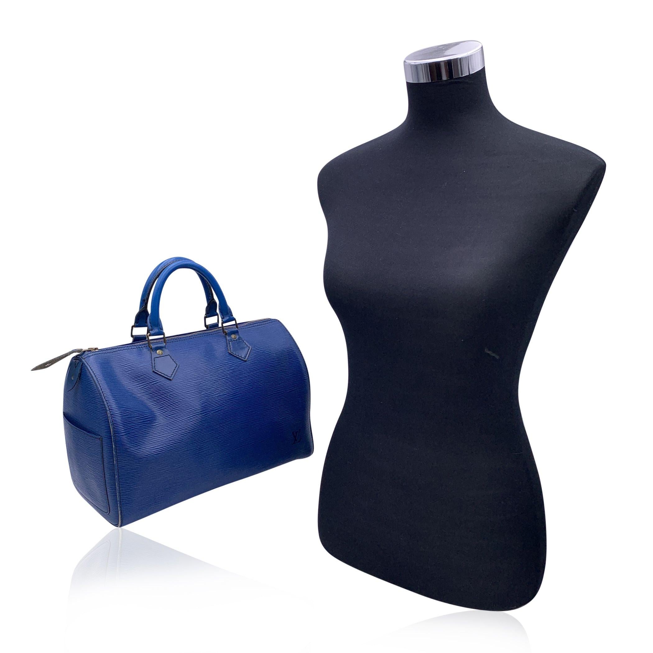 Preciosa Speedy de Louis Vuitton en piel epi azul toledo texturizada. Tiene el tamaño y la forma clásicos de la Speedy 30. El bolso está acentuado con herrajes dorados y tiene dos asas enrolladas, 1 bolsillo lateral abierto en el interior y cierre