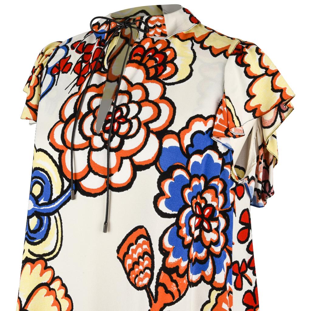Guaranteed authentic Louis Vuitton top featured in ecru with multicolor floral print.
Peter Pan collar with detail and flounce with leather adjustable tie.  
Ruffled cap sleeves. 
Easy tunic style shape.
3.75
