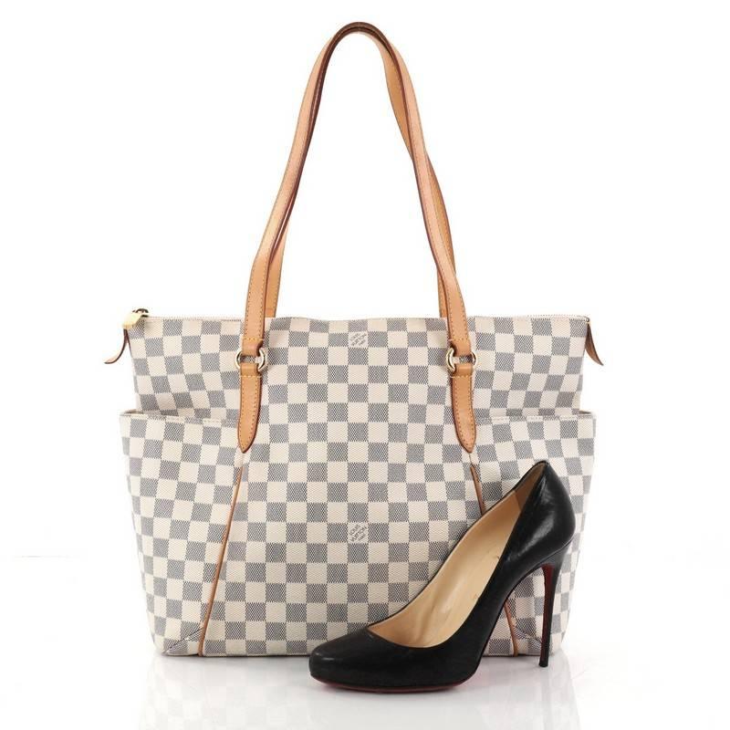 This authentic Louis Vuitton Totally Handbag Damier MM is a chic and practical bag for everyday occasions. Crafted from Louis Vuitton's iconic damier azur coated canvas, this simple city tote features tall cowhide leather handles and trims, two