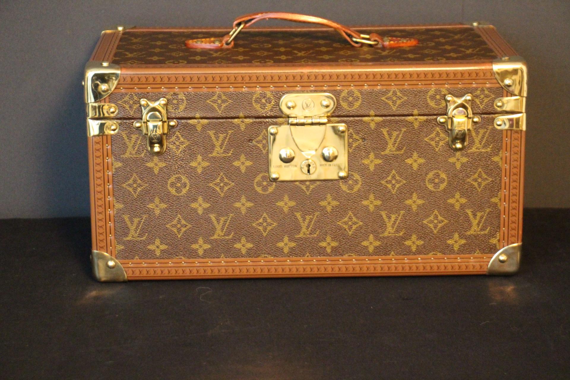 This Louis Vuitton beauty case features monogram canvas and all brass fittings.
All studs are marked Louis Vuitton as well as its top leather handle. All its trim is printed with Louis Vuitton monogram.
Its interior is in beige coated canvas and it