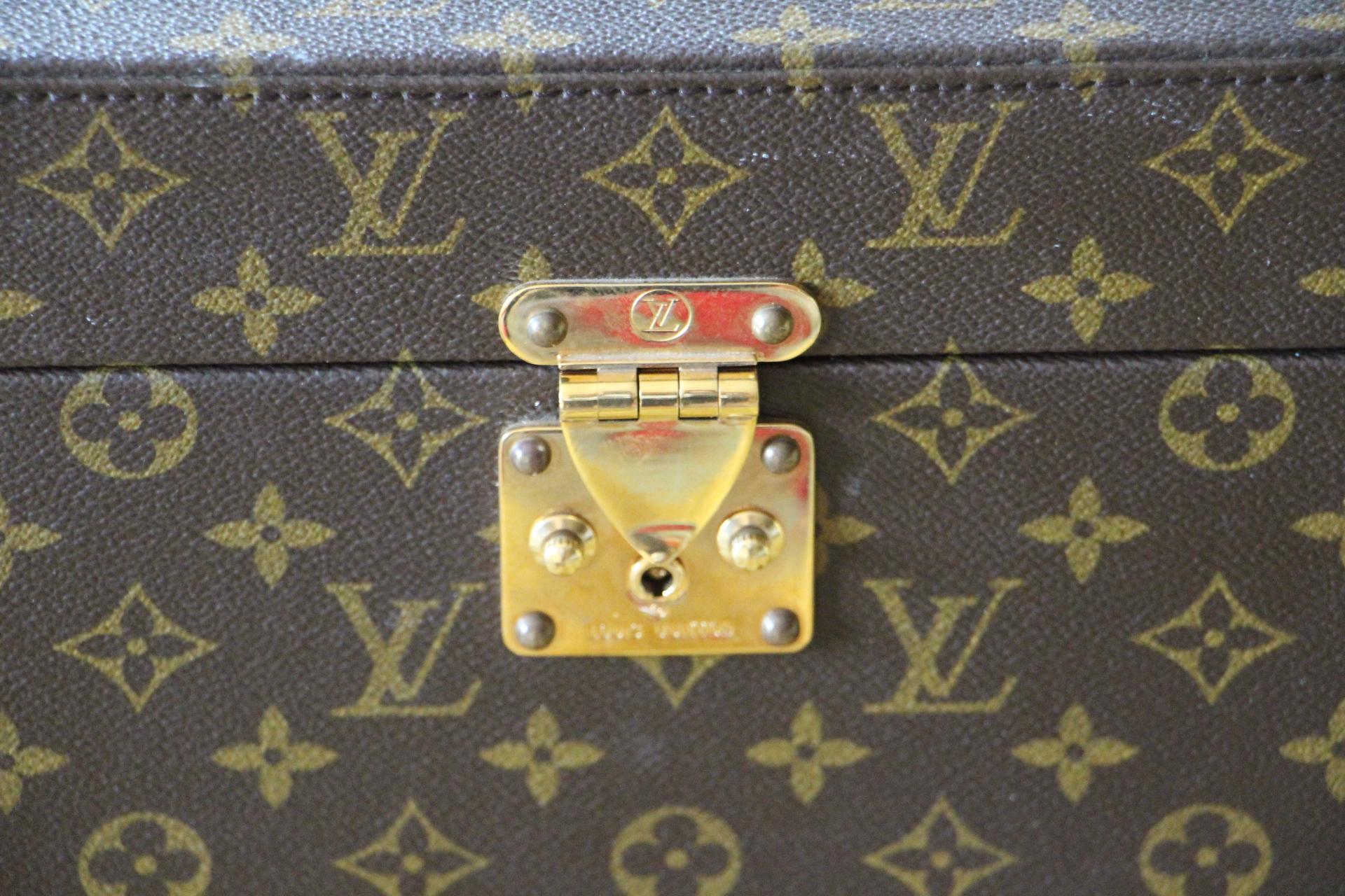 This rigid beauty case features monogram canvas and stamped Louis Vuitton brass lock. Its leather strap is adjustable and is also marked Louis Vuitton.
Interior, beige canvas, leather straps for holding materials. Under its lid there is a mirror.