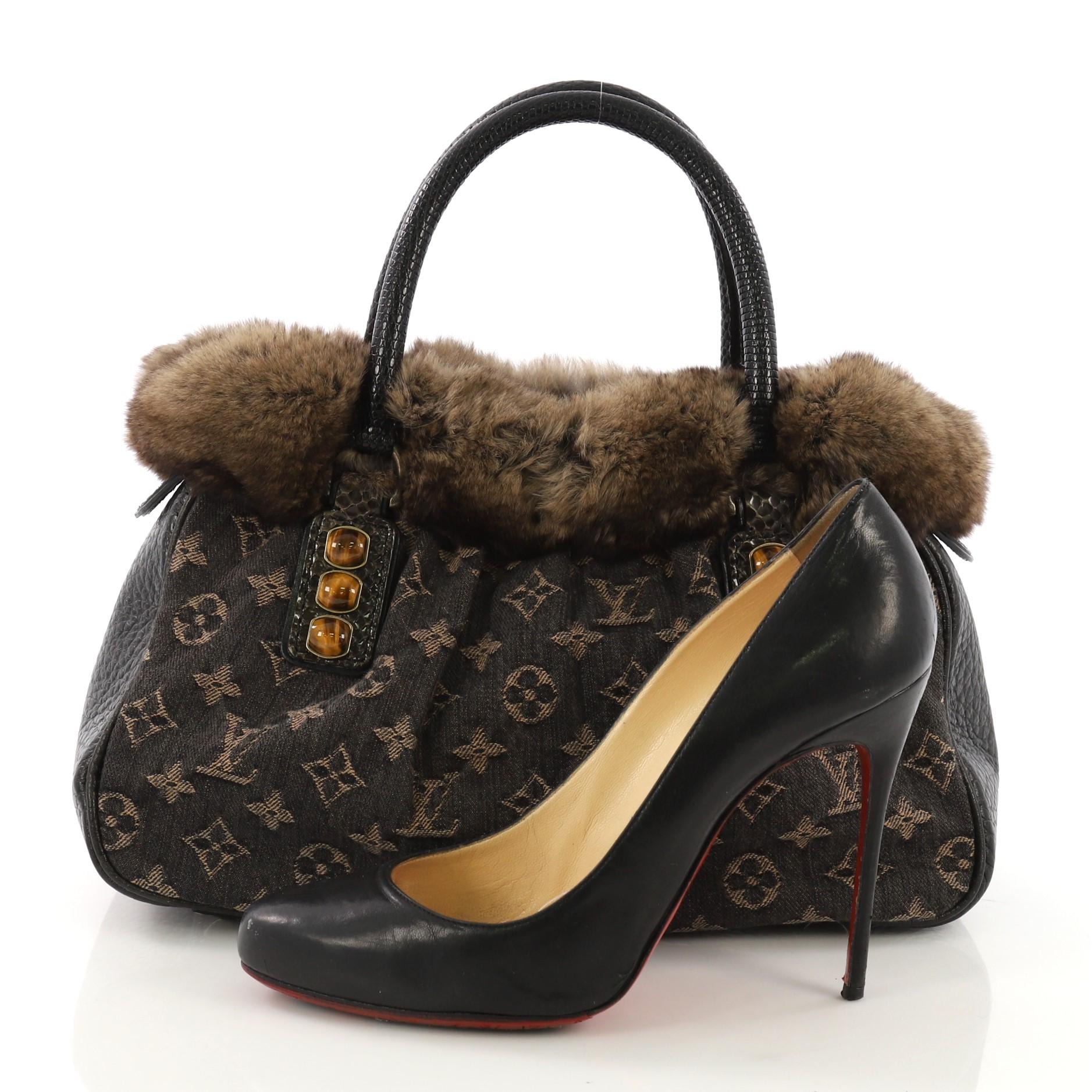 This Louis Vuitton Trapeze Handbag Denim with Fur and Lizard PM, crafted in black denim with genuine lizard and brown fur, features dual rolled handles, protective base studs, tiger eye embellishments, fur rim on top, and aged bronze-tone hardware.