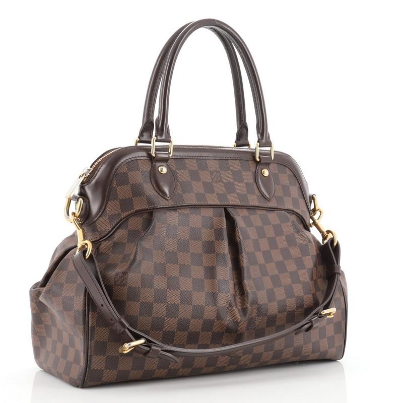 This Louis Vuitton Trevi Handbag Damier GM, crafted from damier ebene coated canvas, features dual rolled handles, leather trim, and gold-tone hardware. Its zip closure opens to a red microfiber interior with slip pockets. Authenticity code reads: