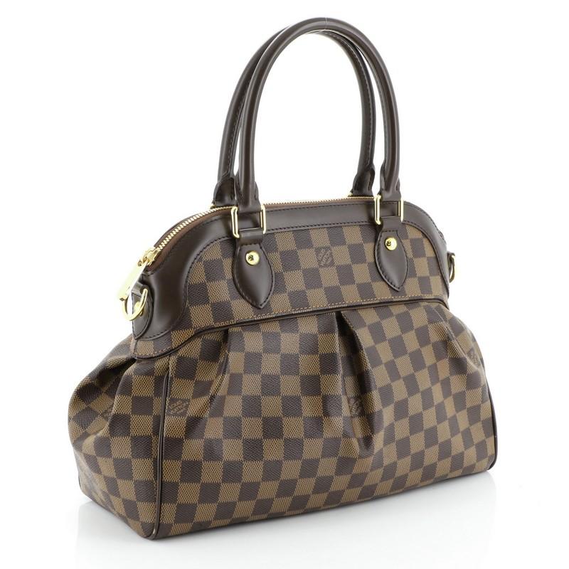 This Louis Vuitton Trevi Handbag Damier PM, crafted from damier ebene coated canvas, features dual rolled handles, leather trim, and gold-tone hardware. Its zip closure opens to a red microfiber interior with slip pockets. Authenticity code reads: