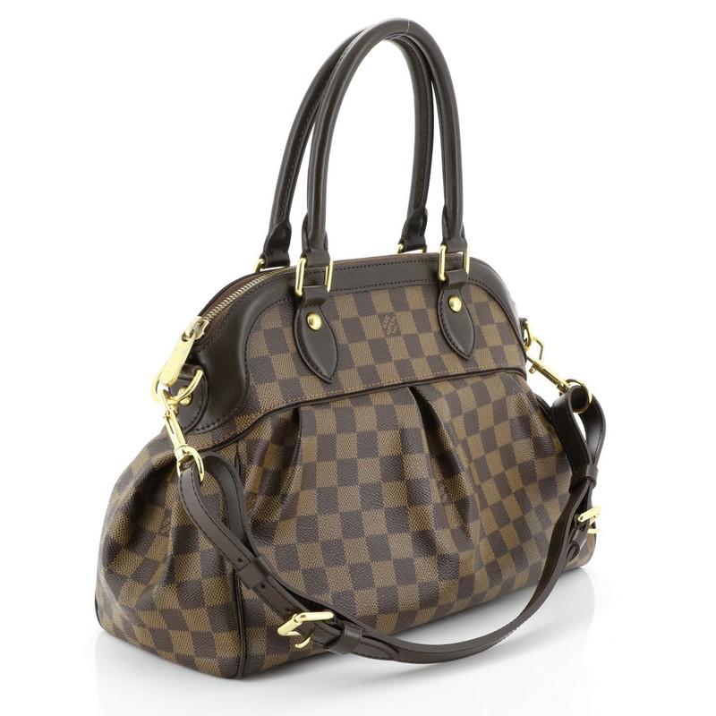 This Louis Vuitton Trevi Handbag Damier PM, crafted from damier ebene coated canvas, features dual rolled handles, leather trim, and gold-tone hardware. Its zip closure opens to a red microfiber interior with slip pockets. Authenticity code reads: