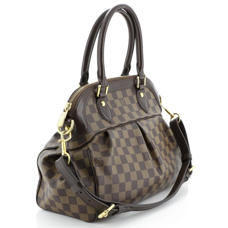 This Louis Vuitton Trevi Handbag Damier PM, crafted from damier ebene coated canvas, features dual rolled handles, leather trim, and gold-tone hardware. Its zip closure opens to a red microfiber interior with slip pockets. Authenticity code reads: