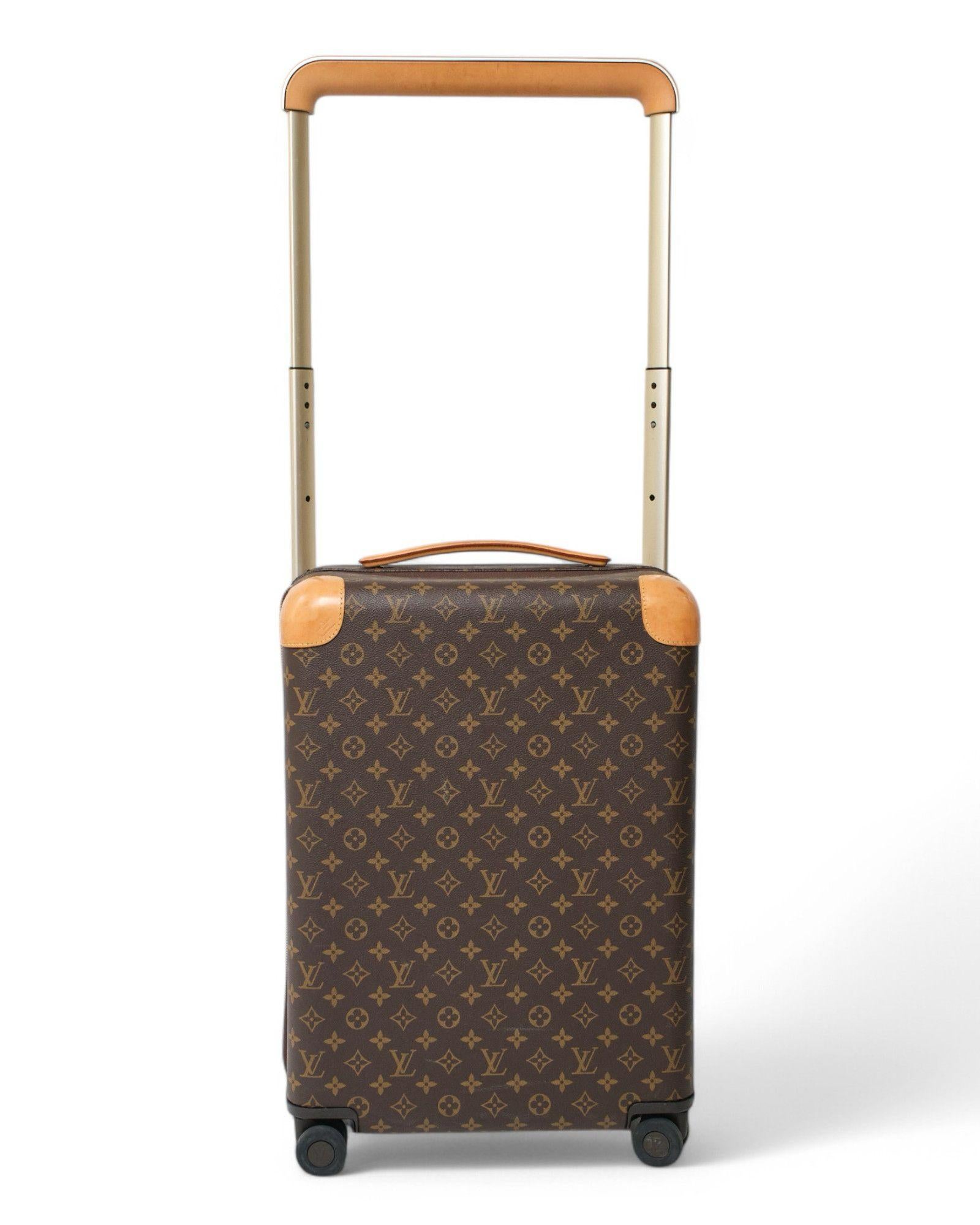 Der charakteristische Trolley von Louis Vuitton, Modell Horizon in Größe 55, aus braunem Segeltuch mit klassischem Monogrammmuster, mit Rindslederbesatz und Metallteilen aus Aluminium. Das für die Größe der Kabine erstaunlich geräumige Modell