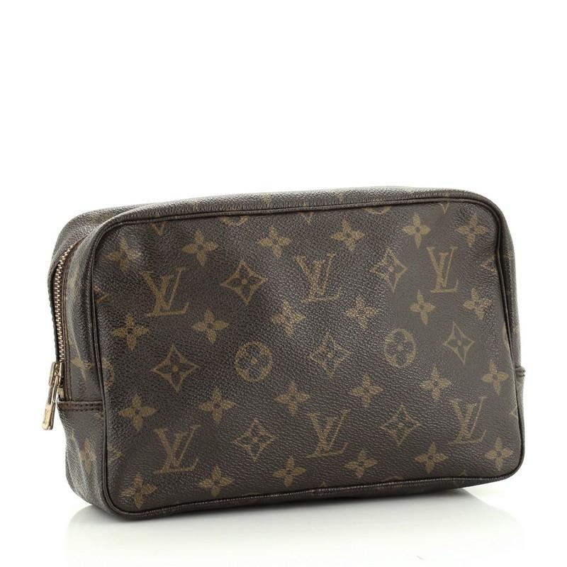 This Louis Vuitton Trousse Toiletry Pouch Monogram Canvas 23, crafted in brown monogram coated canvas, features gold-tone hardware. Its zip closure opens to a neutral leather interior. Authenticity code reads: 862 TH. 

Condition: Good. Wear on base