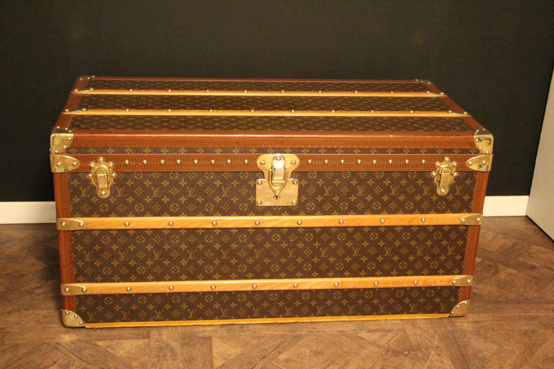 This superb Louis Vuitton steamer trunk features monogram canvas, honey color lozine trim, LV stamped solid brass locks and clasps, studs as well as leather side handles and brass corners. 
All its lozine trims are printed LV.
It has got a