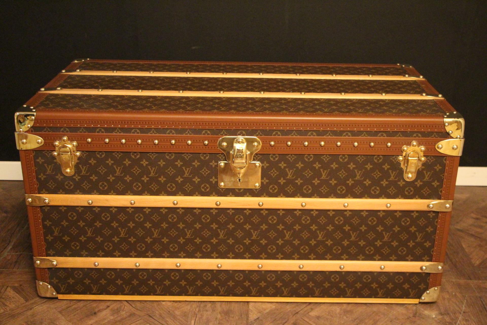 Cette superbe malle Louis Vuitton présente une toile monogramme, une garniture en lozine couleur miel, des serrures et des fermoirs en laiton massif estampillés LV, des clous ainsi que des poignées latérales en cuir et des coins en laiton. 
Toutes