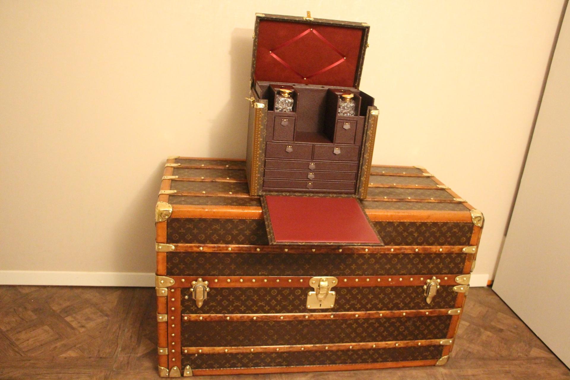 This magnificent Louis Vuitton trunk features monogram canvas, lozine trim, solid brass lock, cowhide leather top handle with its name holder and its clochette hiding its 2 original working keys.
It opens vertically to reveal a breathtaking inside.